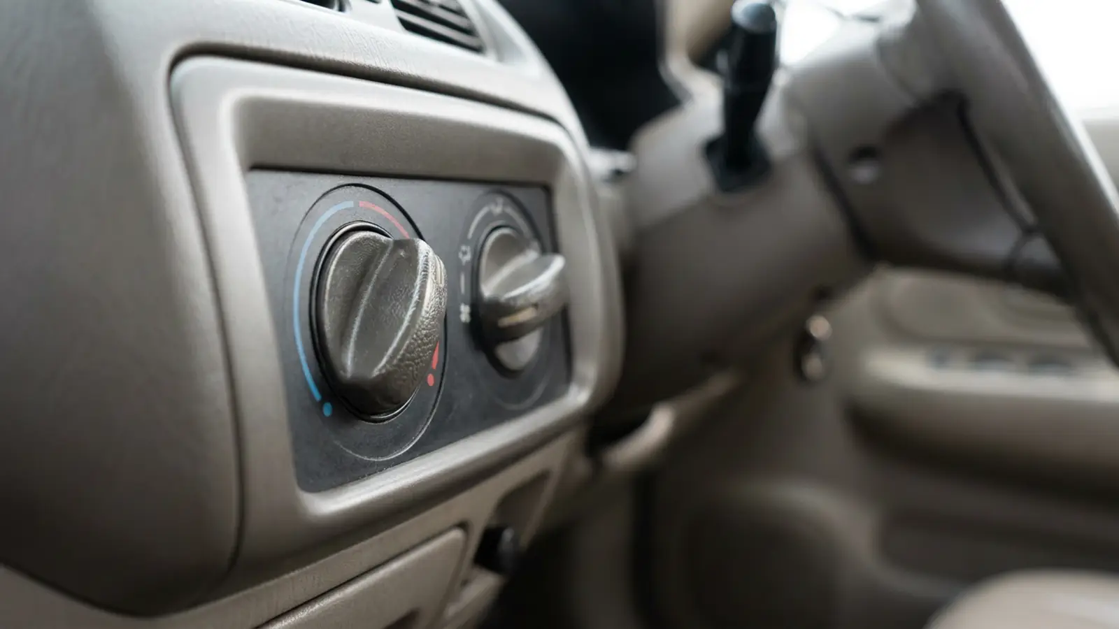 A close-up of the rotary climate control knobs on a car dashboard panel