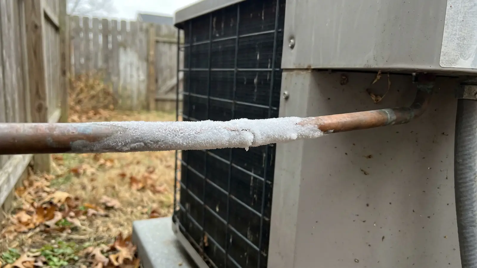 Frost forming along the copper suction line where it enters an outdoor condenser unit